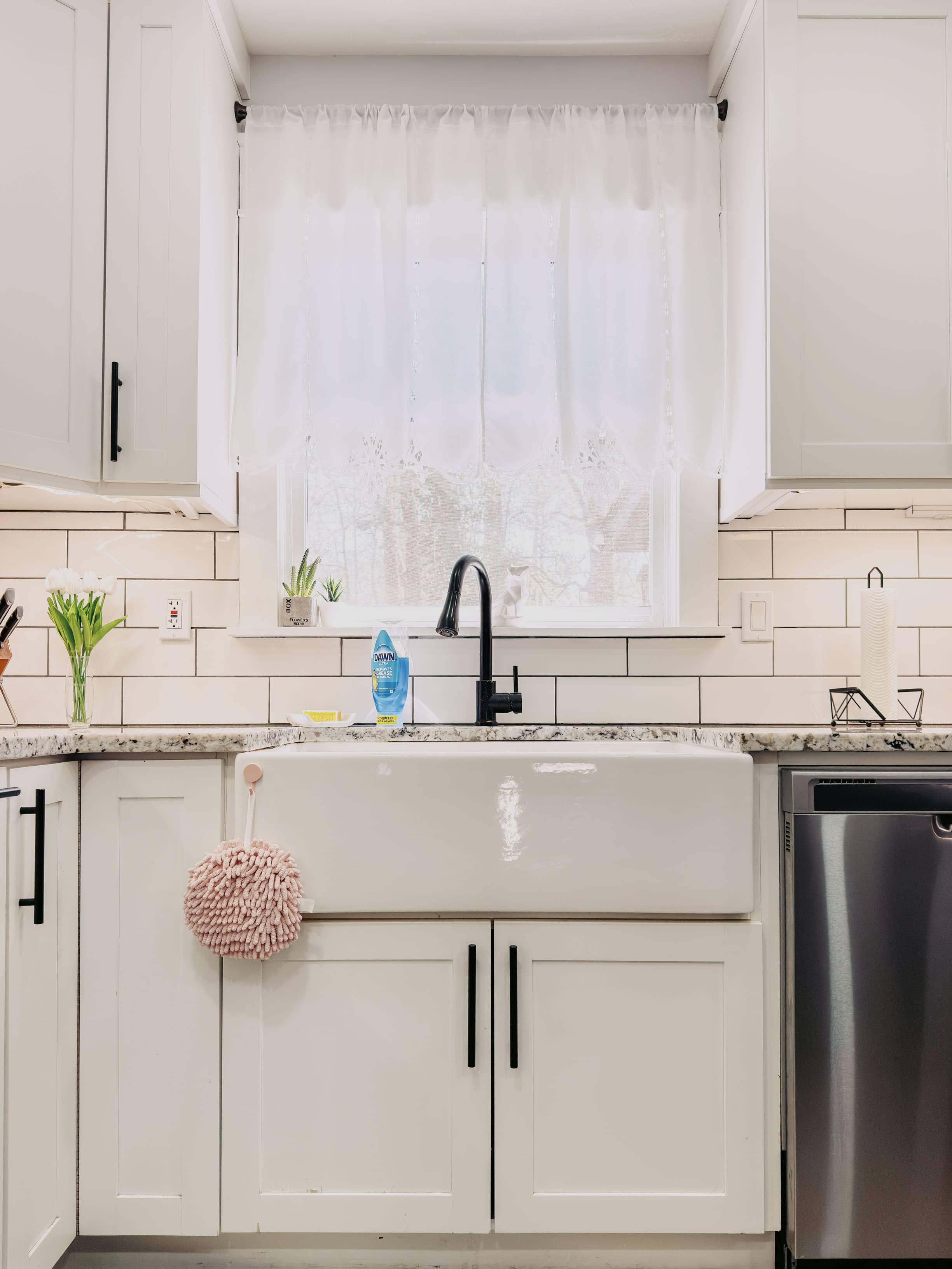 Custom farmhouse apron sink set into a built-in base cabinet with matching cabinetry by GM Cabinetry