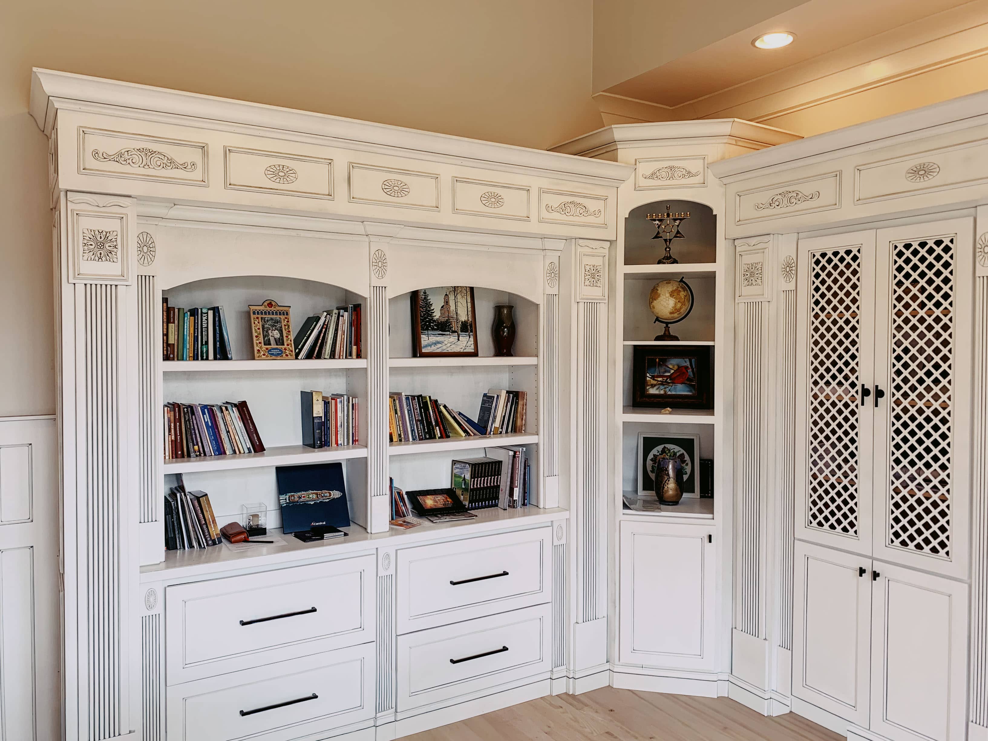 Floor-to-ceiling custom built-in bookshelf with white cabinet doors and open shelving by GM Cabinetry