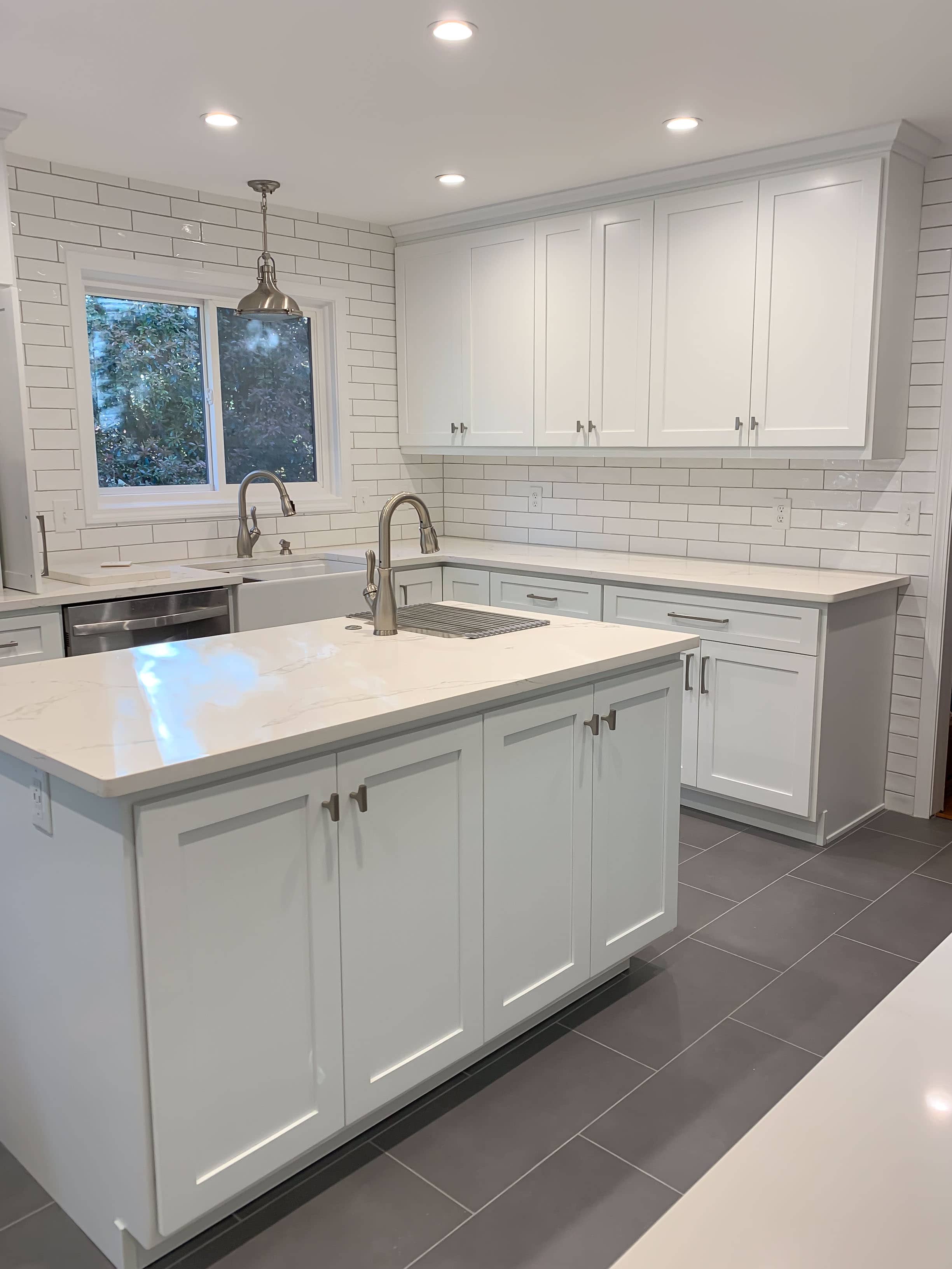 White shaker kitchen cabinets with subway tile backsplash and grey quartz countertops installed in Georgia home