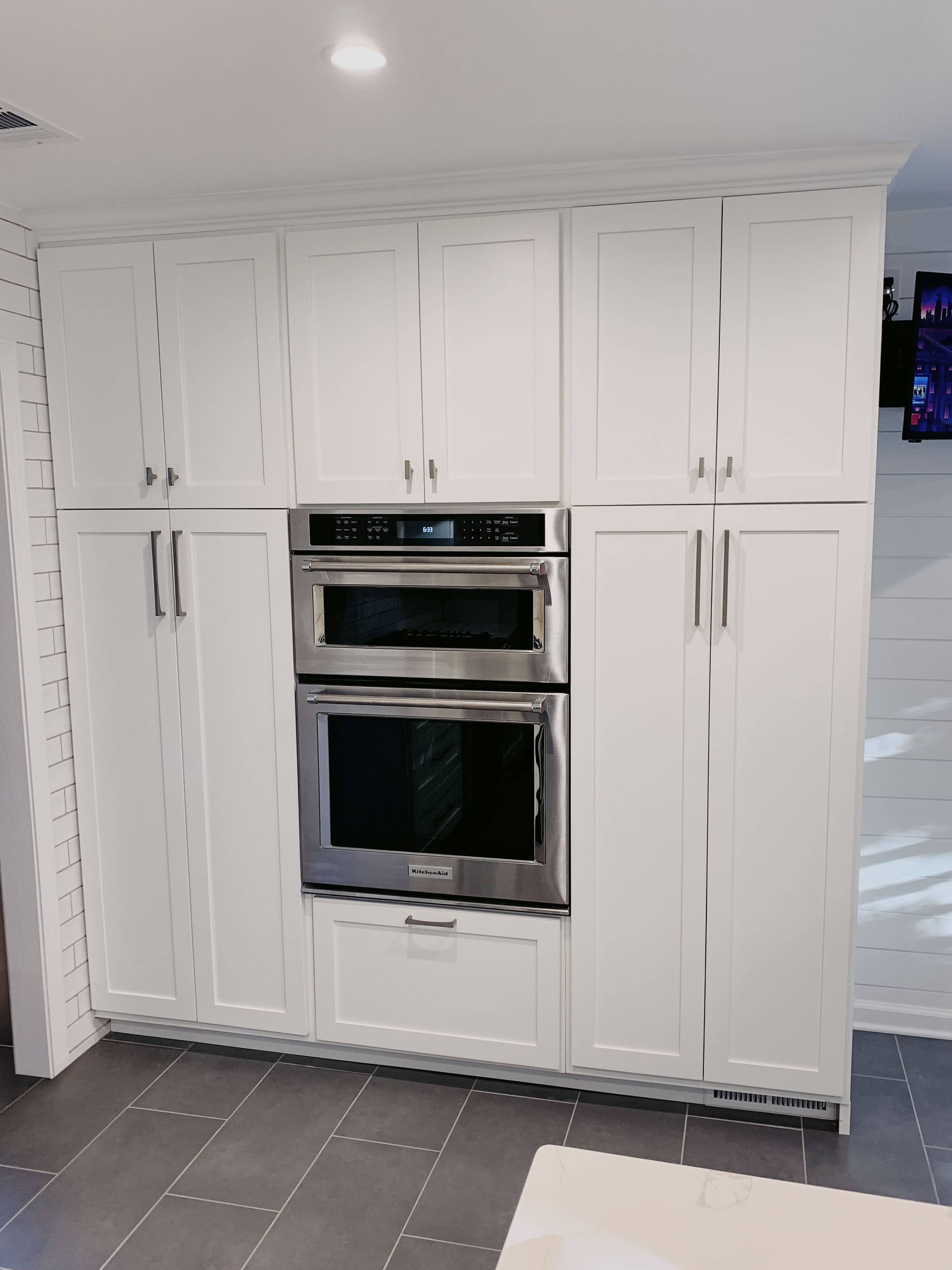 Completed custom kitchen with white shaker cabinets, built-in appliances, and quartz countertops in Georgia