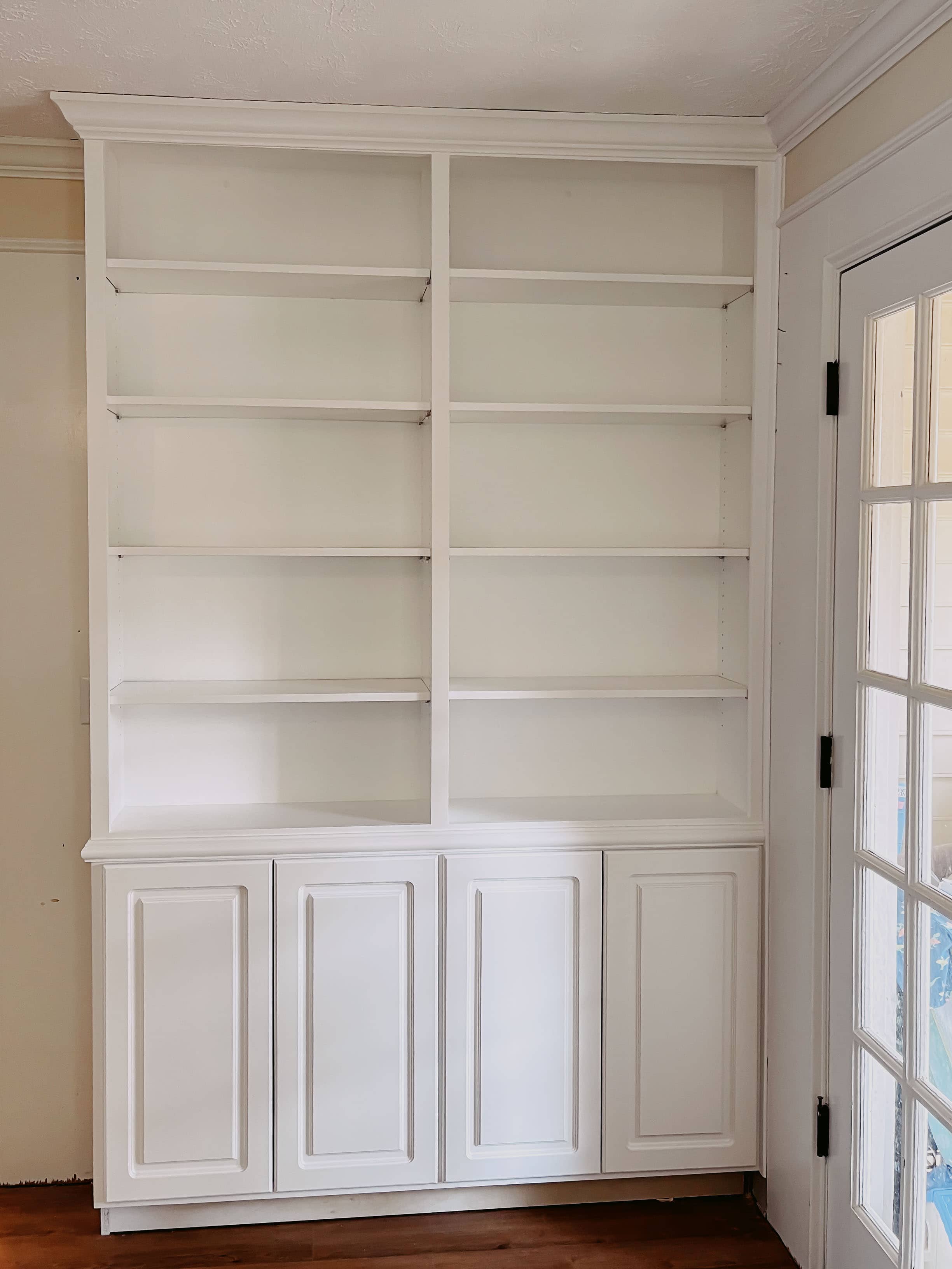 White built-in bookcase with raised-panel lower doors and crown molding installed in Georgia home