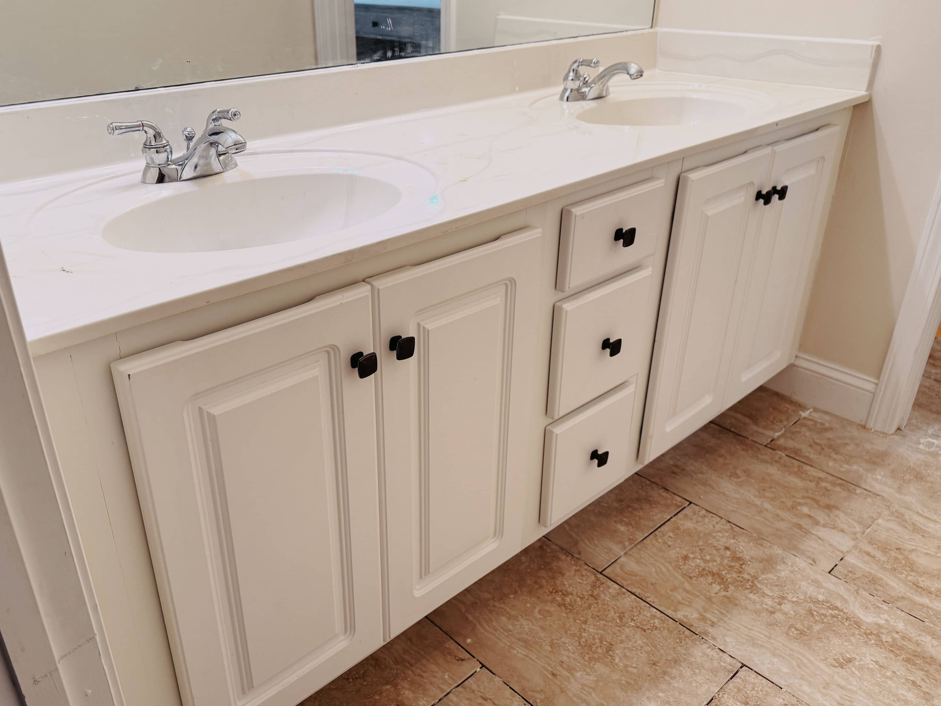 Modern double sink bathroom vanity in white painted raised-panel style with marble countertop